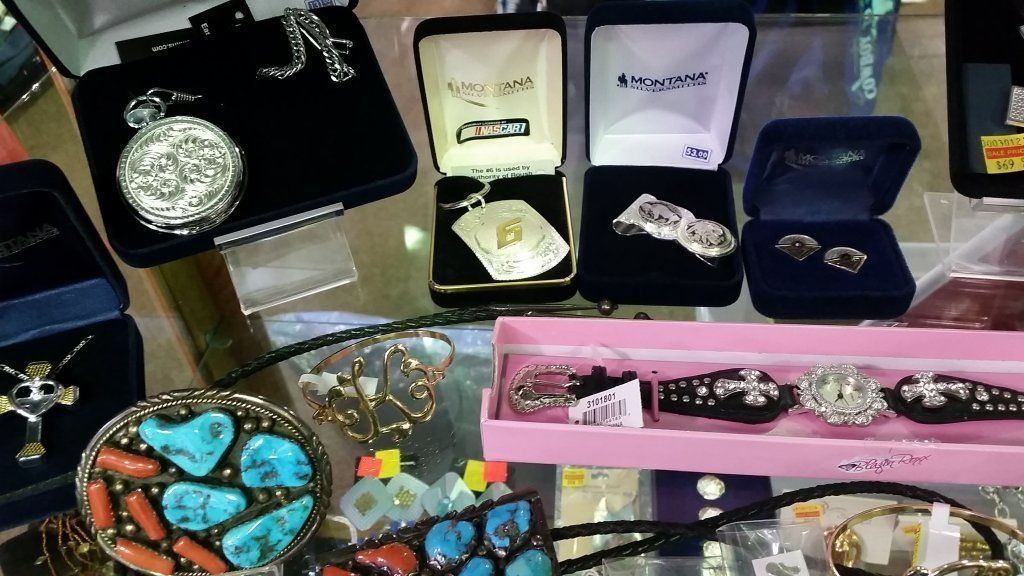 Jewelry display: pocket watches, necklaces, earrings, bracelets, and belt buckles in various boxes.