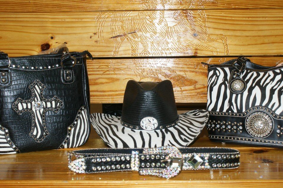 Three stylish zebra print purses and a hat with a cross design.