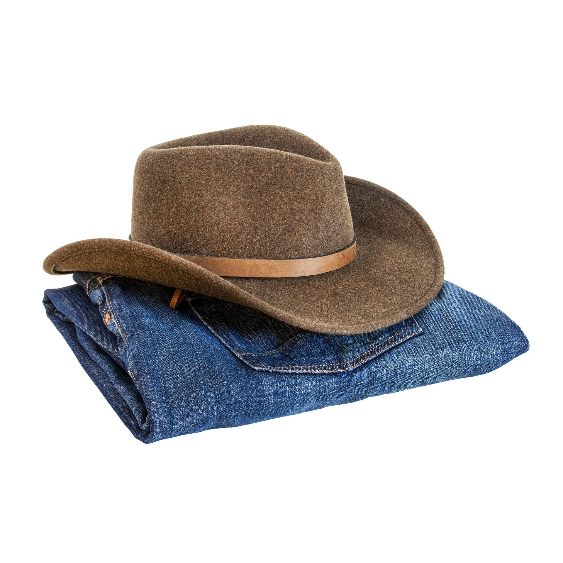 Brown cowboy hat on top of folded blue jeans.