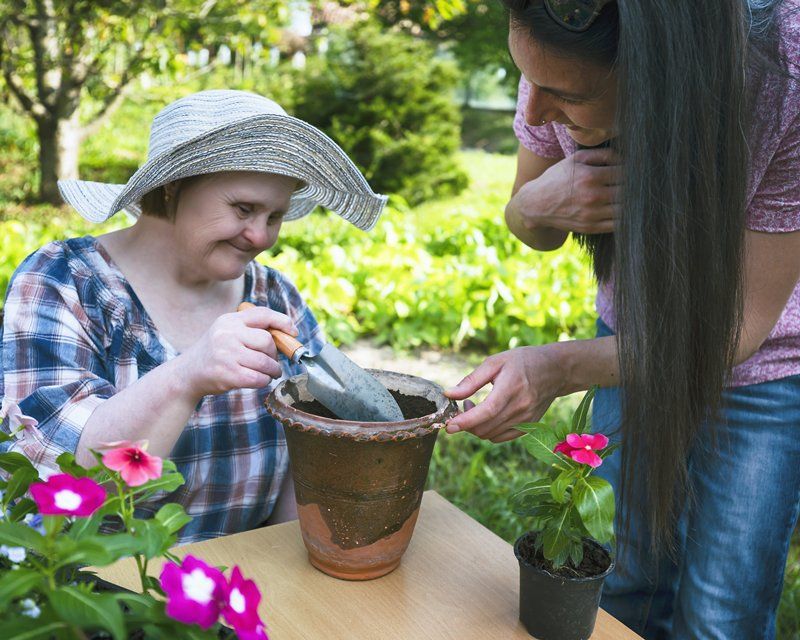 Woman with Down Syndrome Planting Flowers — VIC & NSW — KaizenCare