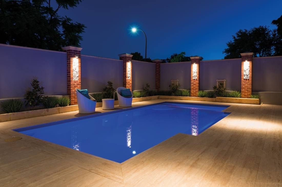 Nighttime View of a Rectangular Swimming Pool With Surrounding Patio — Creative Pools and Spas in Sorrento, VIC
