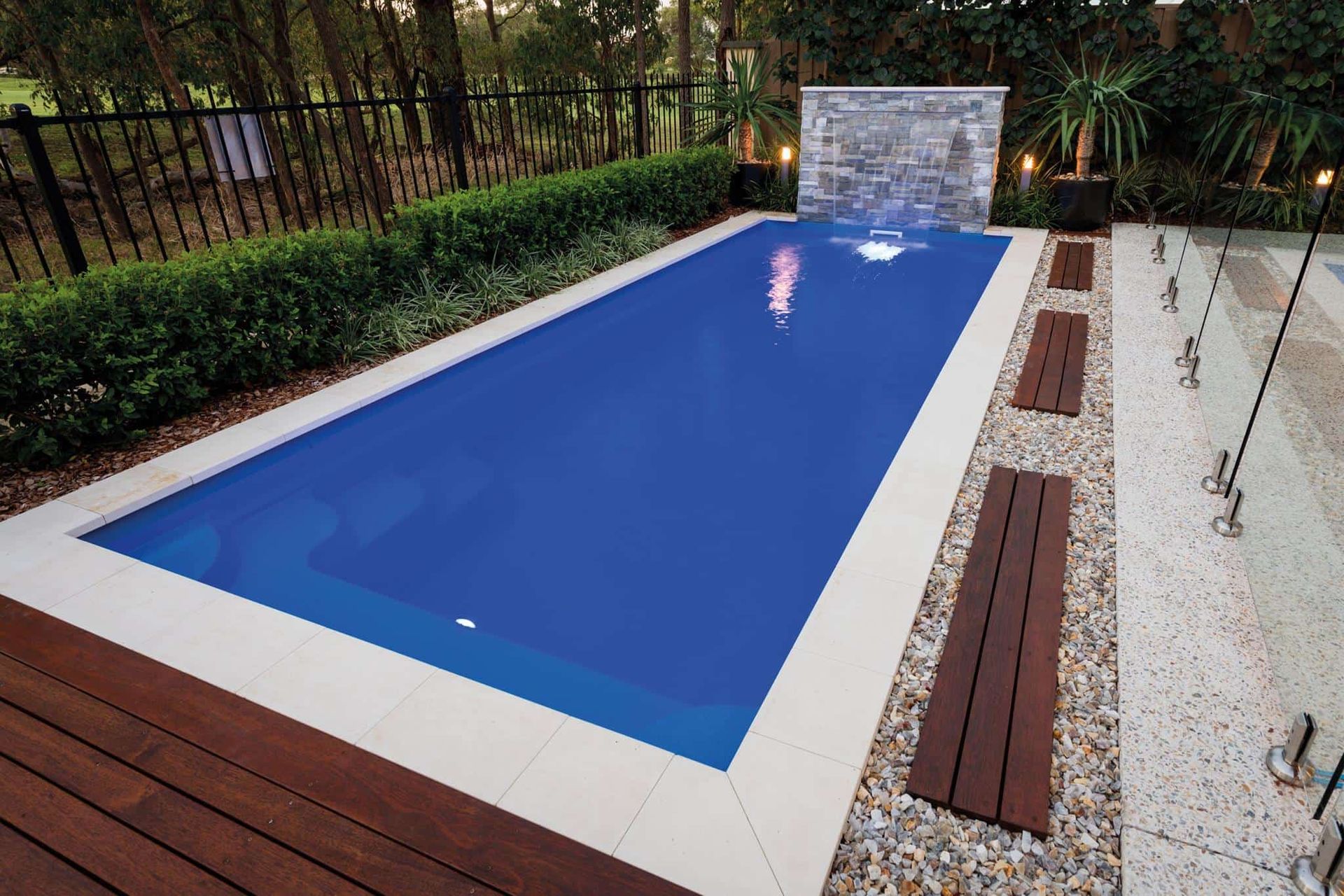 Rectangular Blue Pool With White Coping and Wood Decking — Creative Pools and Spas in Mount Martha, VIC
