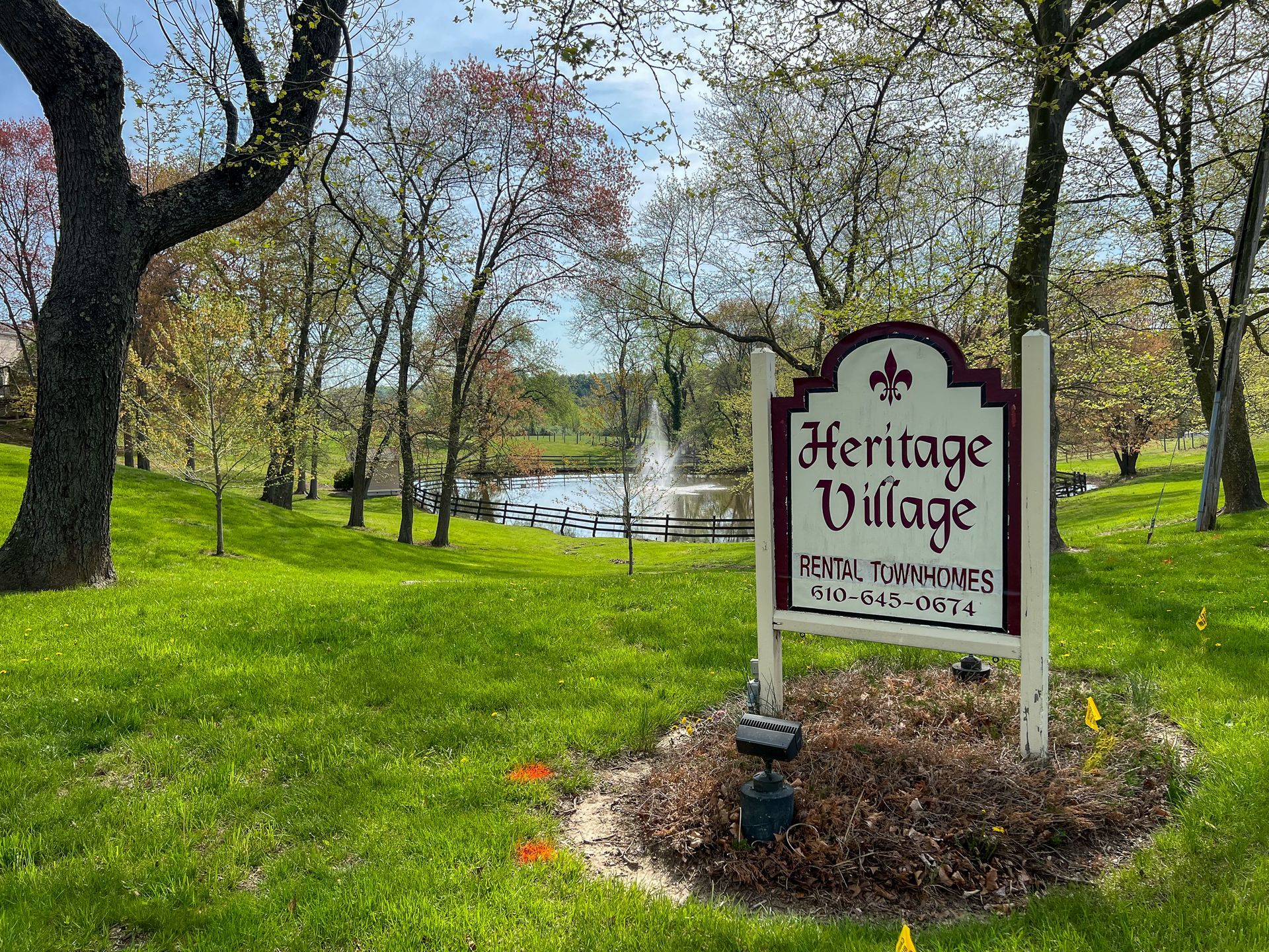 The main business sign with the pond and water fountain in the background at Heritage Village Landenberg
