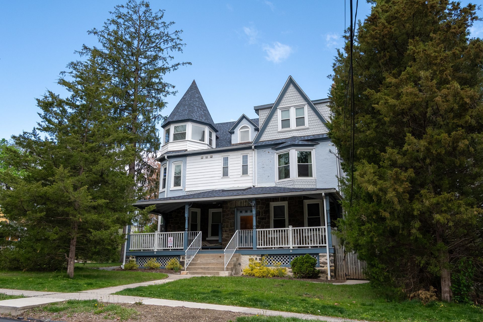 A blue and white house with a porch and stairs.