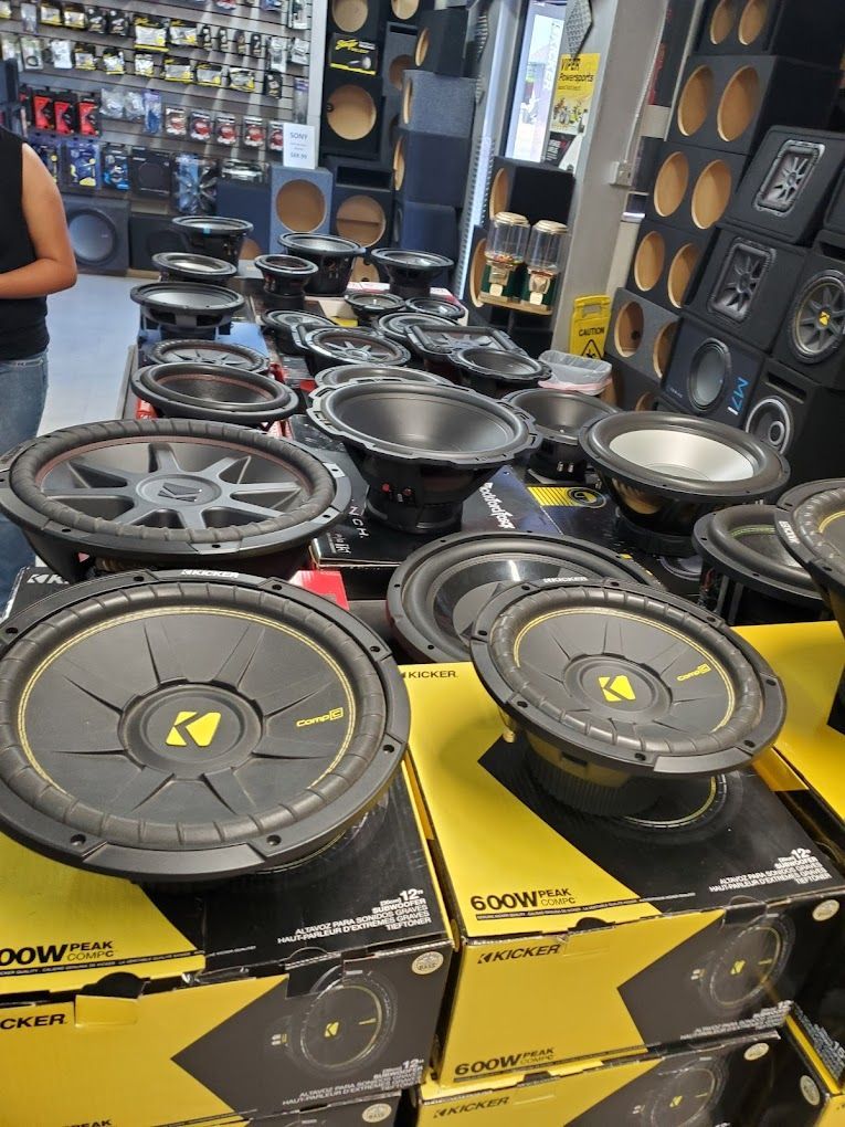 a lot of speakers are stacked on top of each other in a store