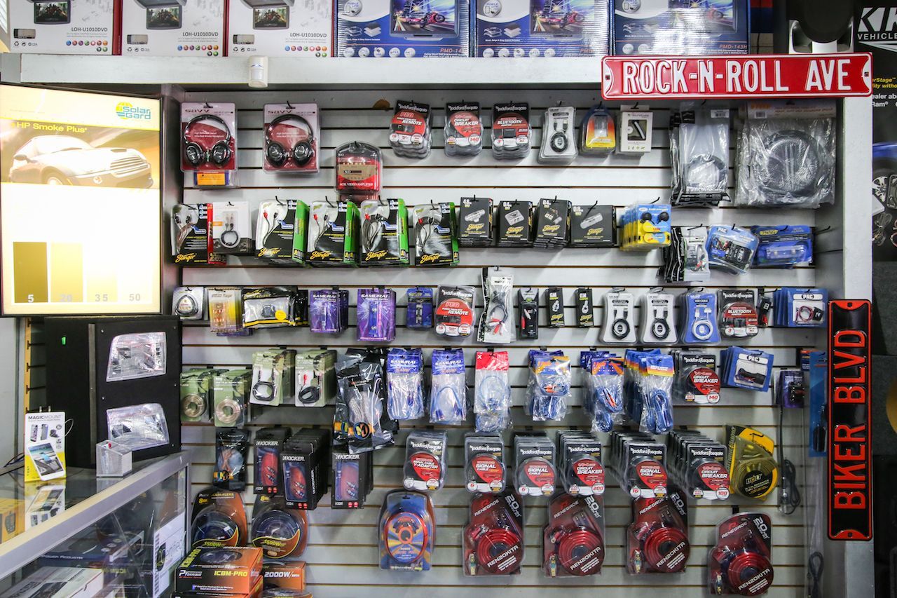 Shelves stocked with car accessories in a store; products are in various packaging.