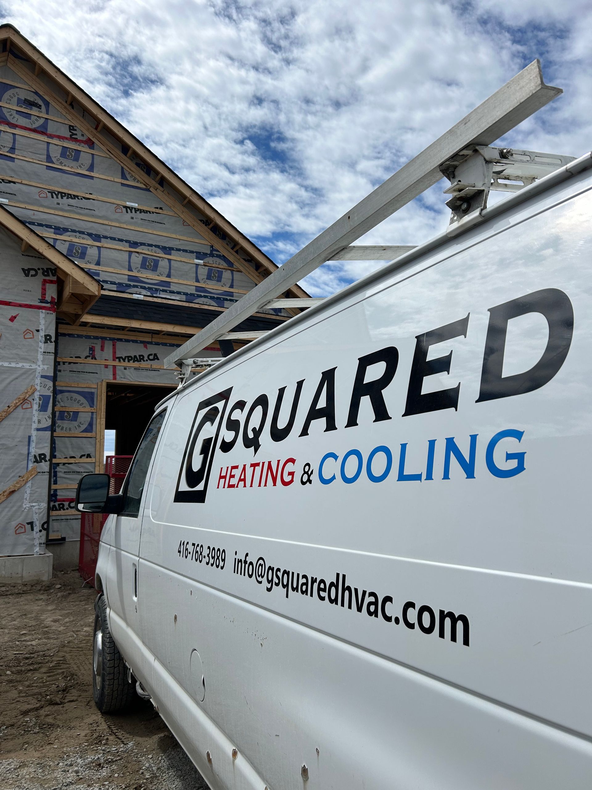 A white van is parked in front of a house under construction.