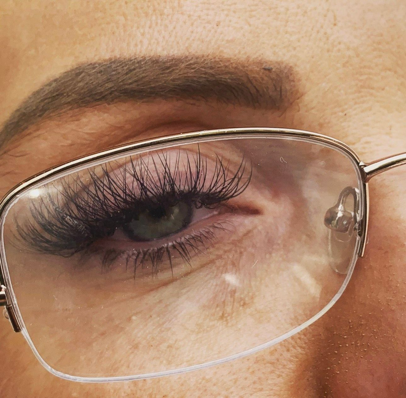 A close up of a woman wearing glasses with long eyelashes| St. Louis, MO | Lashing Out Loud