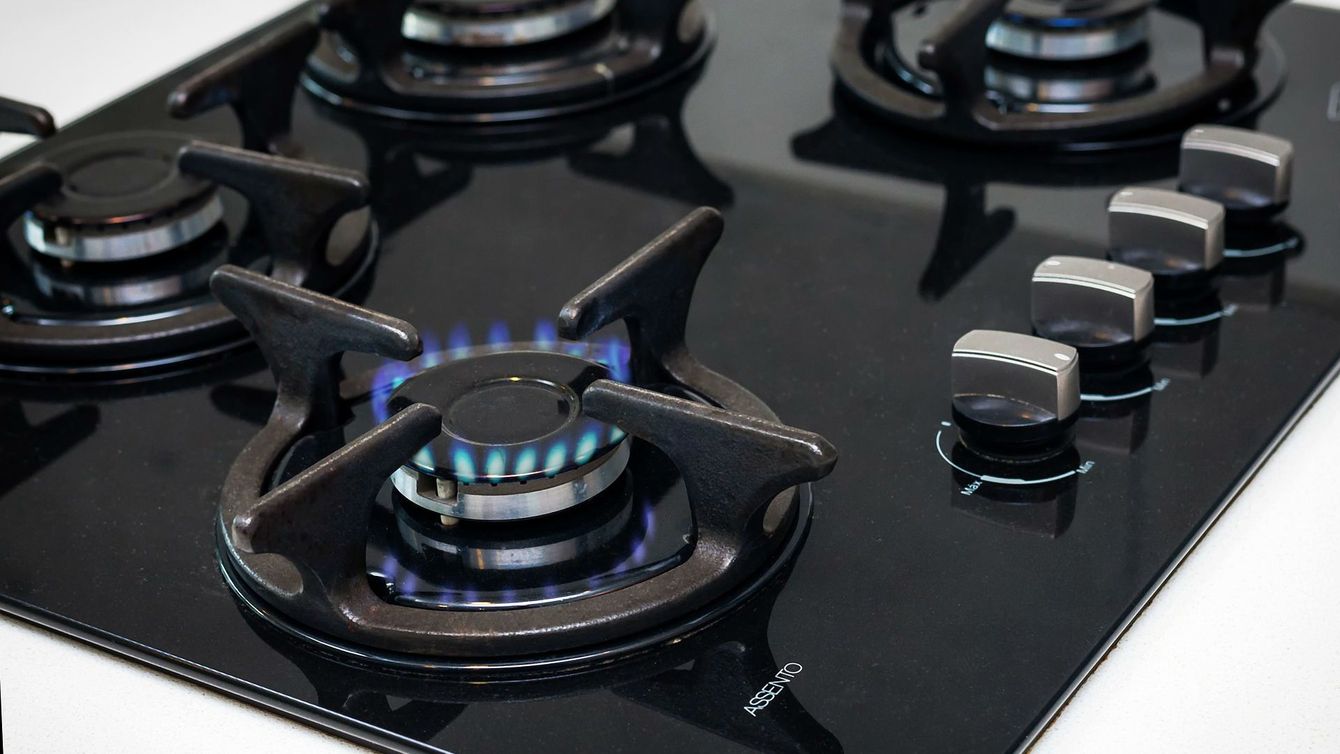 A close up of a gas stove with a blue flame