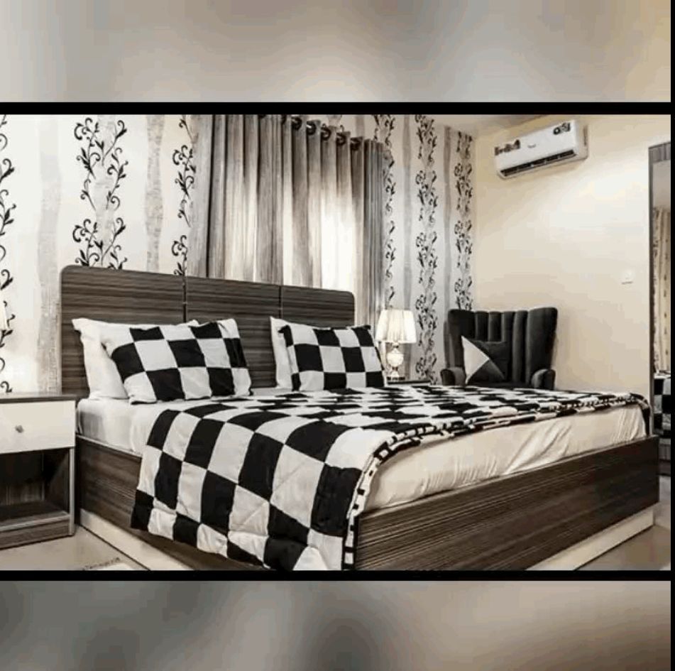 A black and white photo of a bedroom with a checkered bedspread