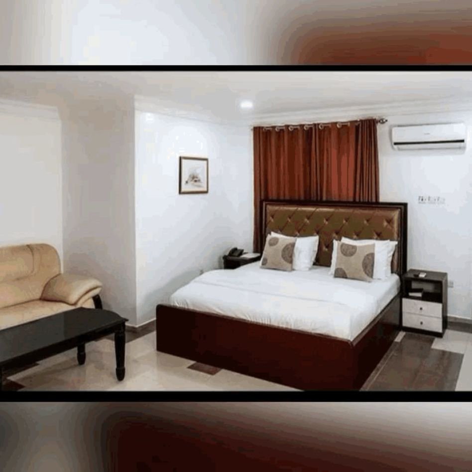 A hotel room with a large bed and a couch