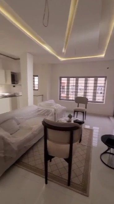A living room with a couch , chair , table and window.