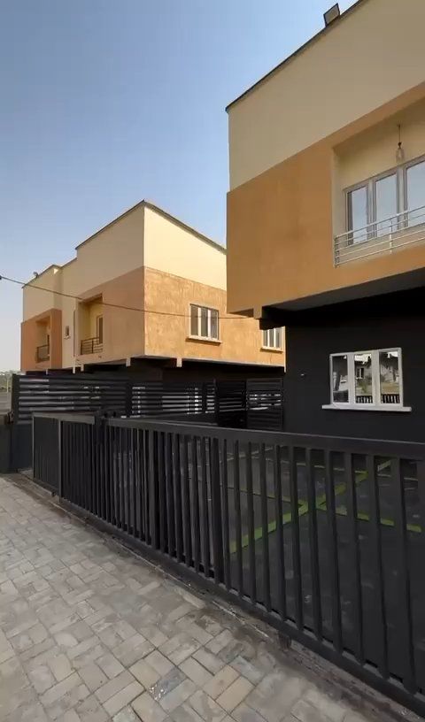 A row of houses with a black fence in front of them