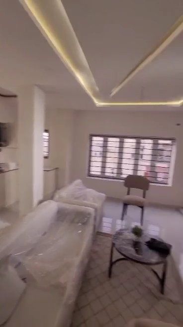 A living room with a couch , chair , table and window.