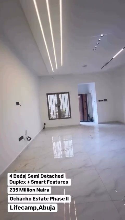 A living room with white walls and a marble floor.