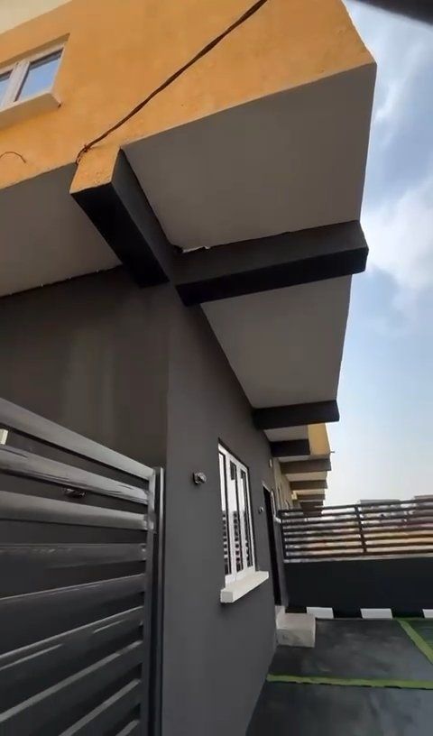 A building with a fence and a window on the side of it.
