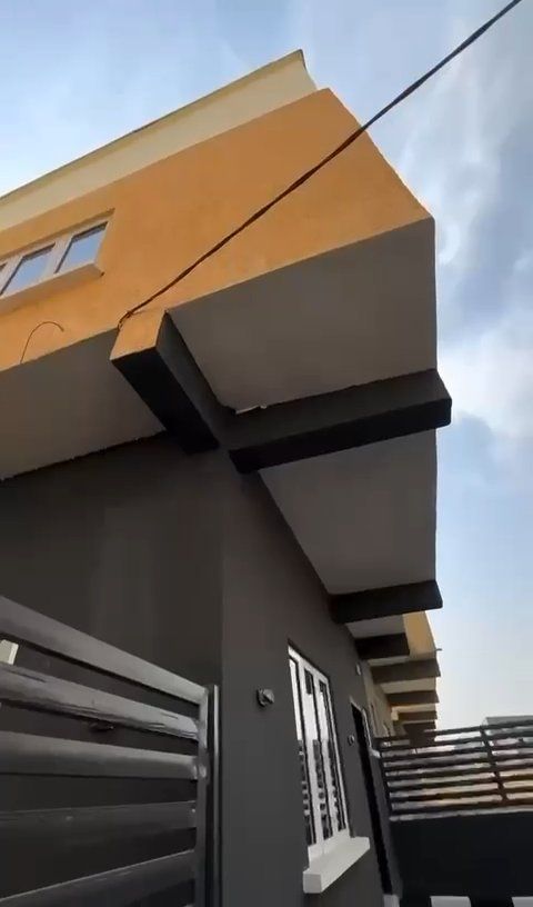 A building with a balcony and a fence in front of it