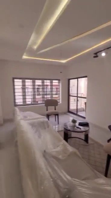 A living room with a couch , chairs , a table and a window.