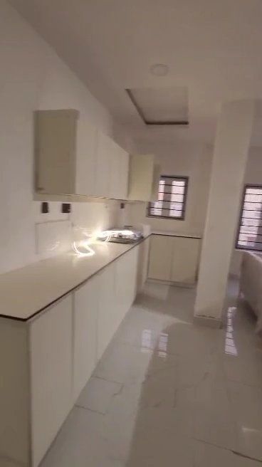 A kitchen with white cabinets , a sink , and a window.