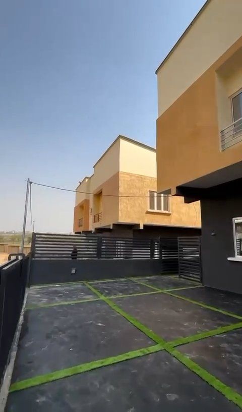 A row of houses with a green driveway in front of them.