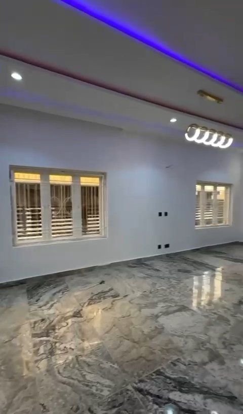 A large empty room with a marble floor and a lot of windows.