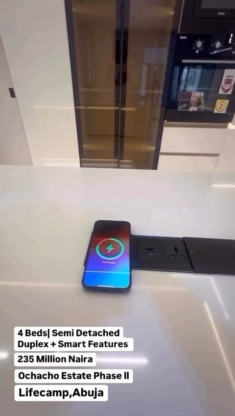 A cell phone is sitting on the floor in a kitchen.