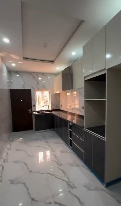 A kitchen with a lot of cabinets and a marble floor.