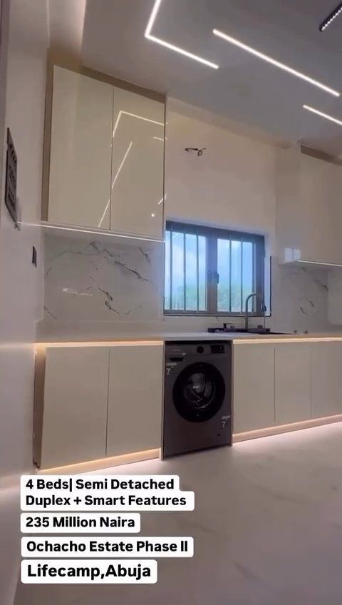 A kitchen with white cabinets and a washer and dryer