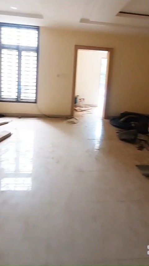 A large empty room with a window and a door.