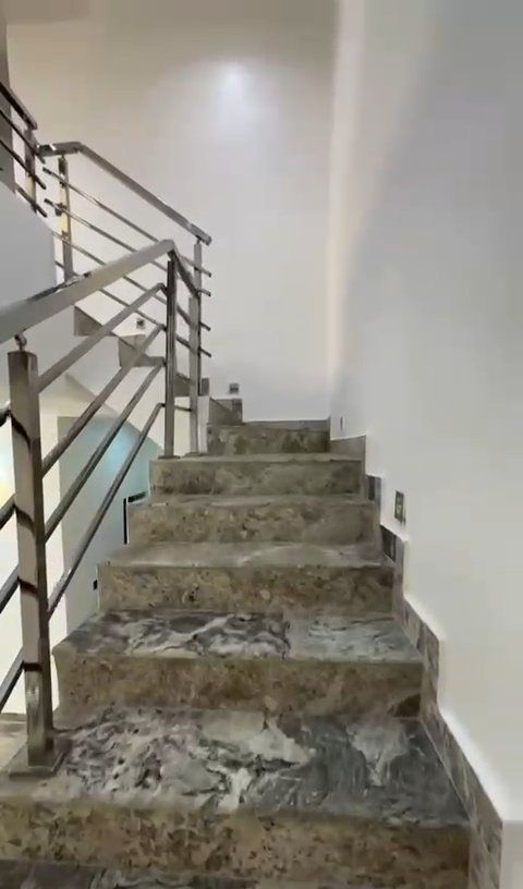 A set of stairs leading up to a second floor with a metal railing.