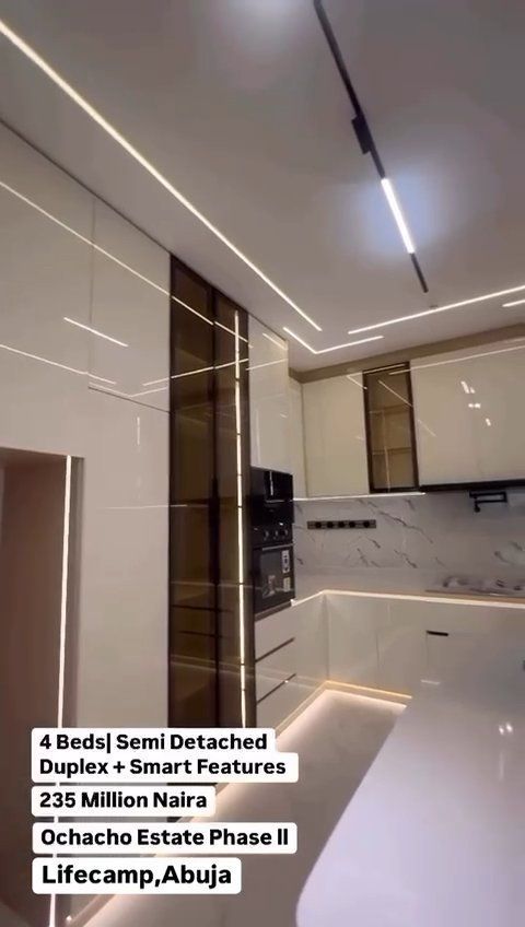 A kitchen with a lot of cabinets and lights on the ceiling