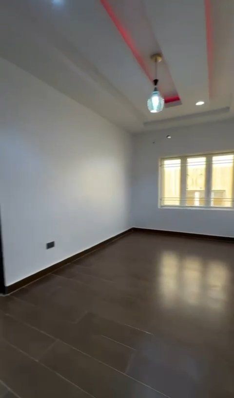 An empty room with a wooden floor and white walls