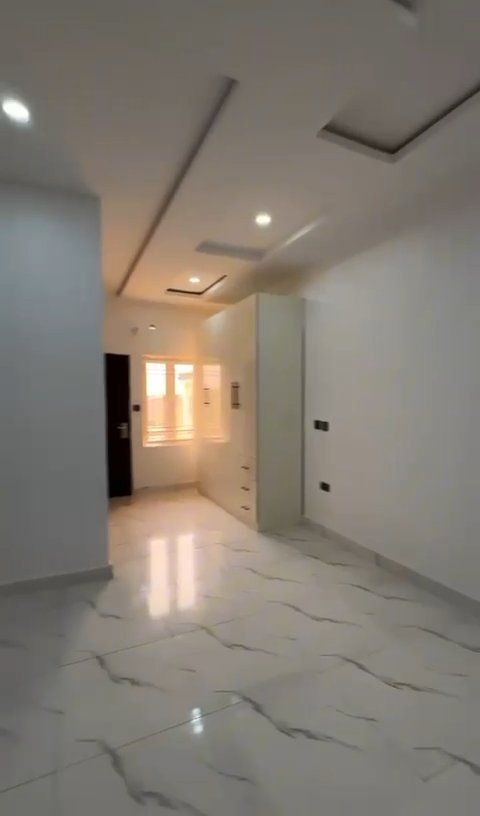 An empty room with marble floors and white walls