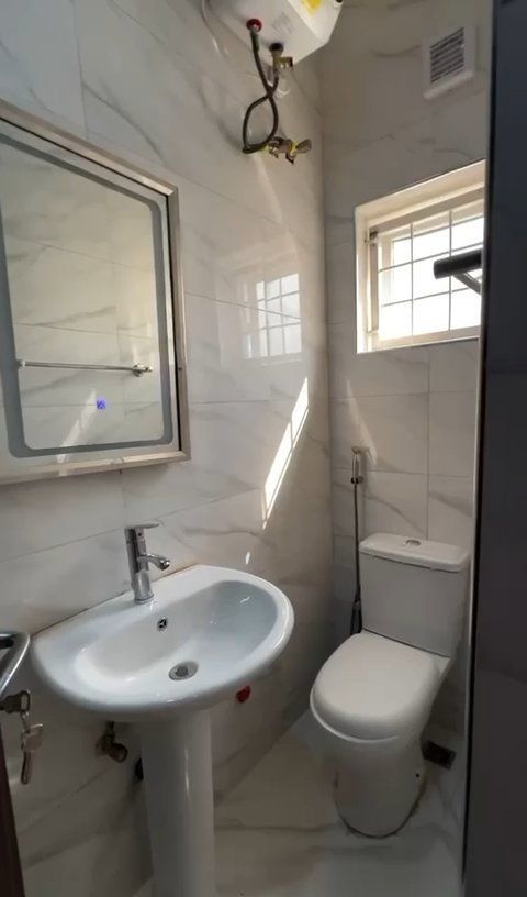 A bathroom with a sink , toilet and mirror.