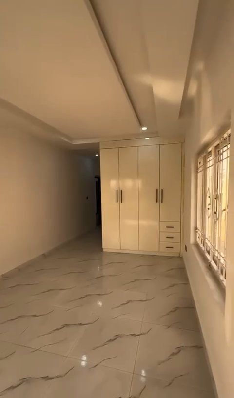 A large empty room with a lot of windows and a marble floor.