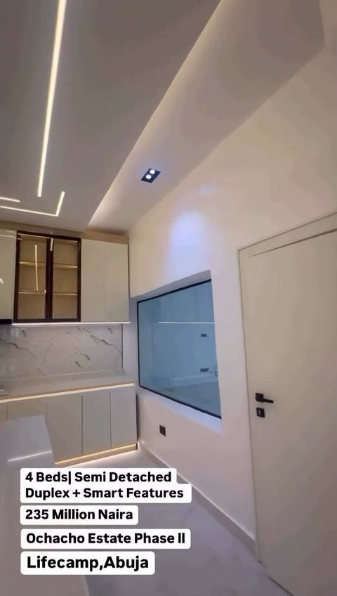 A kitchen with white cabinets and a large window.