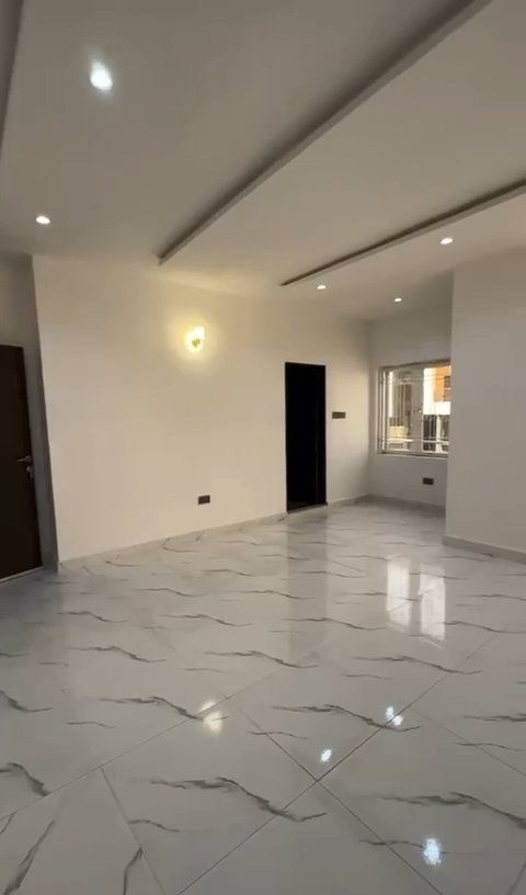 A large empty room with marble floors and white walls.