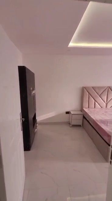A bedroom with a bed , nightstand , and television.