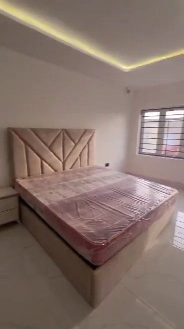 A bedroom with a bed , nightstand , and window.