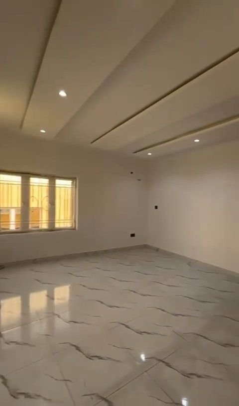 An empty room with a marble floor and white walls