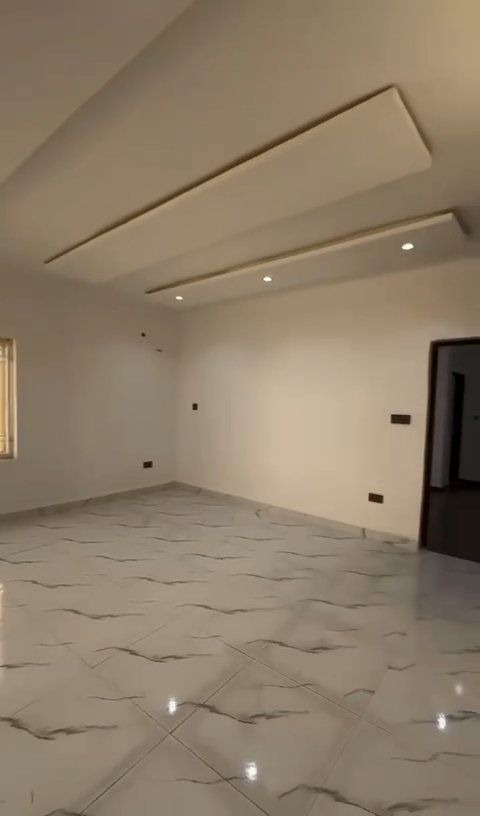 An empty room with a tiled floor and white walls