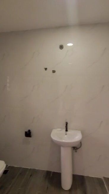 A bathroom with a pedestal sink and a toilet.