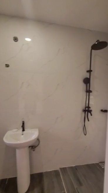 A bathroom with a sink and a shower head.