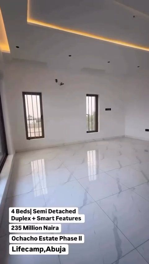 An empty room with a white tile floor and a ceiling.