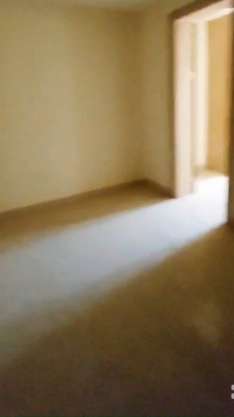 An empty room with a doorway and a window.