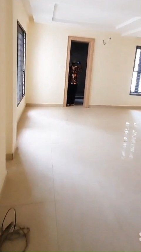 A large empty room with a door and windows.