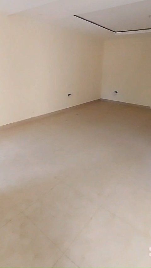 An empty room with a tiled floor and white walls.