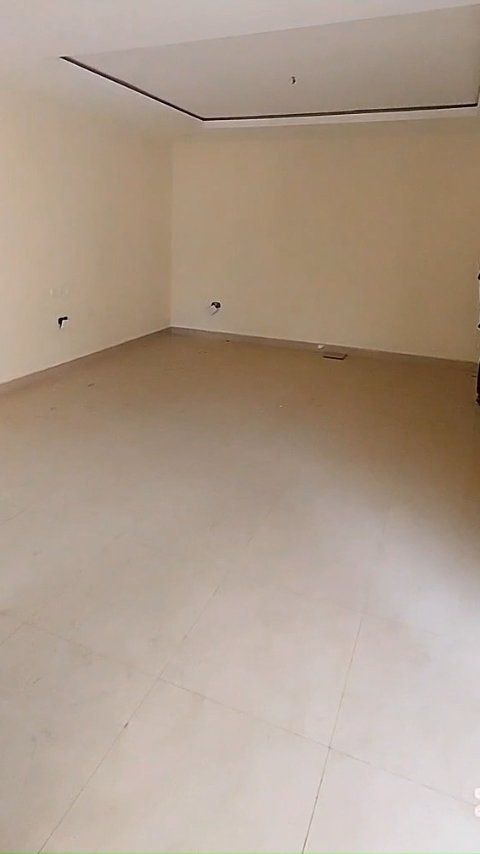 An empty room with a tiled floor and white walls.
