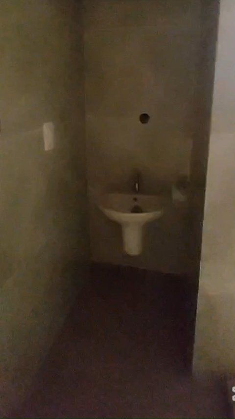 A bathroom with a sink and a toilet in a dark room.