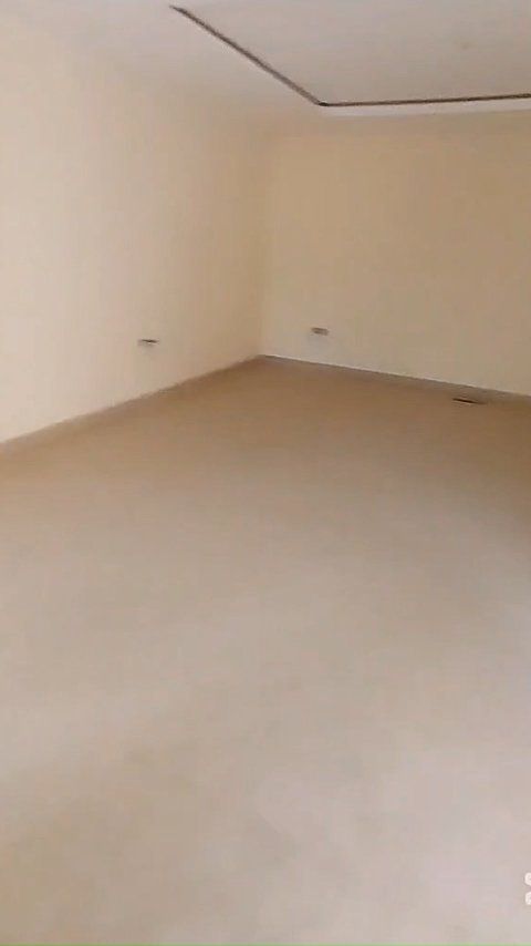 An empty room with a beige floor and white walls.